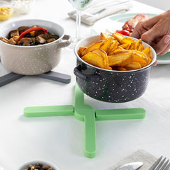 Töpfe mit Speisen und ein grüner Folvet-Topfuntersetzer auf einem Tisch