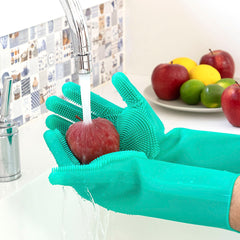 Grüne Silikonhandschuhe halten einen Apfel unter fließendem Wasser