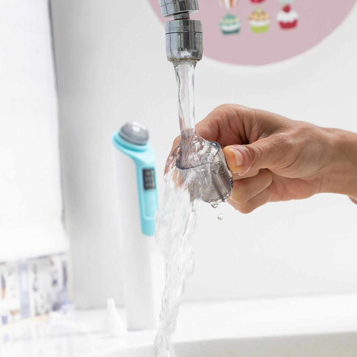Abgenommener transparenter Nizi-Filterkopf beim Reinigen unter Wasser, Gerät im Hintergrund