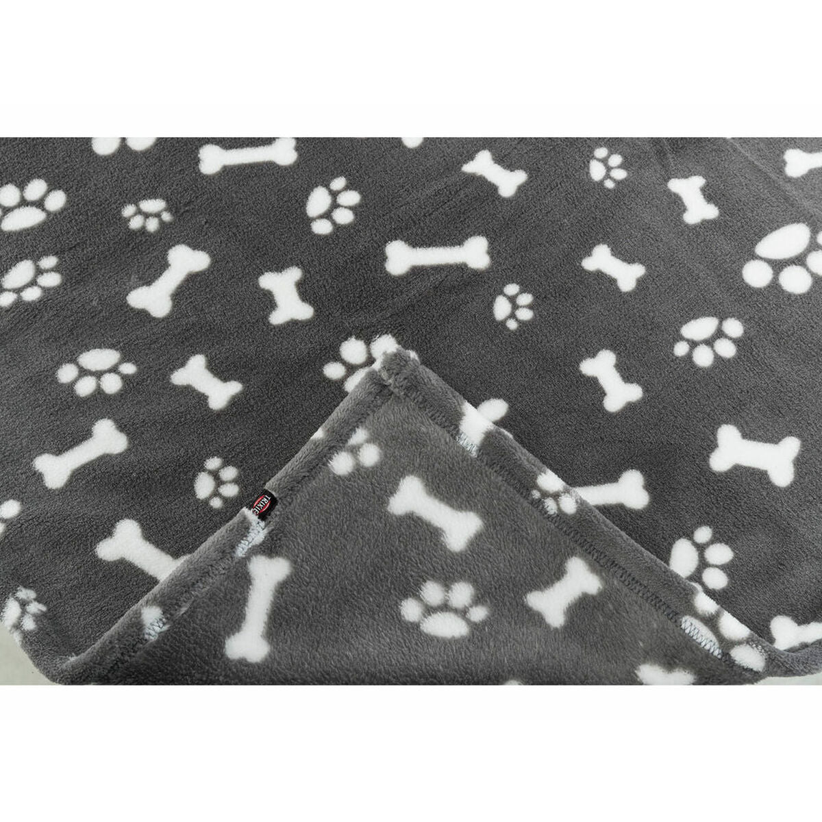 Nahaufnahme des grauen Plüschs mit weißen Motiven und gefalteter Deckenecke