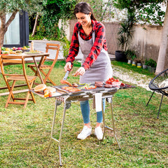 Person nutzt den ExelQ-Grill mit seitlichen Ablagen im Garten