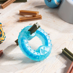Blauer Glubiz-Beißring mit Leckerli im Schlitz auf einem Tisch