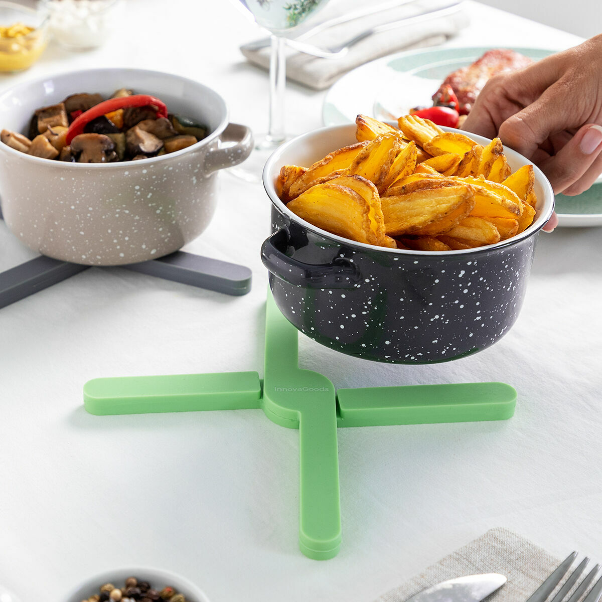 Töpfe mit Speisen und ein grüner Folvet-Topfuntersetzer auf einem Tisch