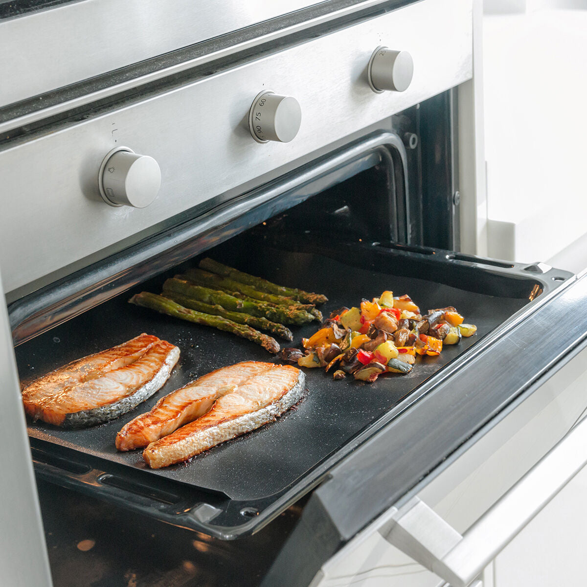 InnovaGoods Backmatte auf einem Backblech im geöffneten Backofen mit Lebensmitteln