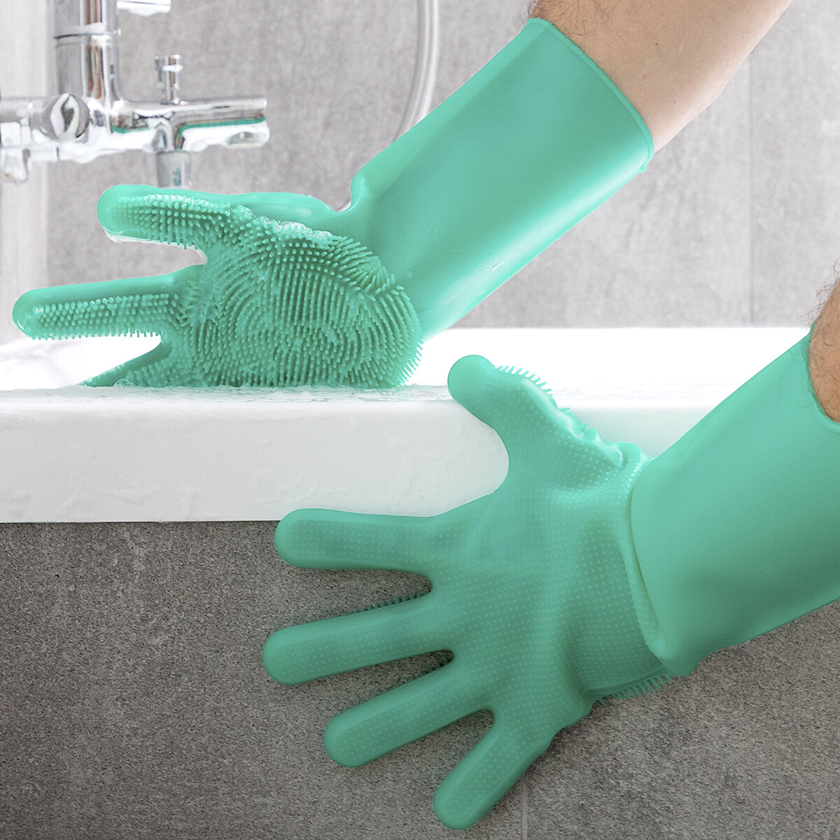Grüne Silikonhandschuhe werden an Waschbecken und Armatur verwendet