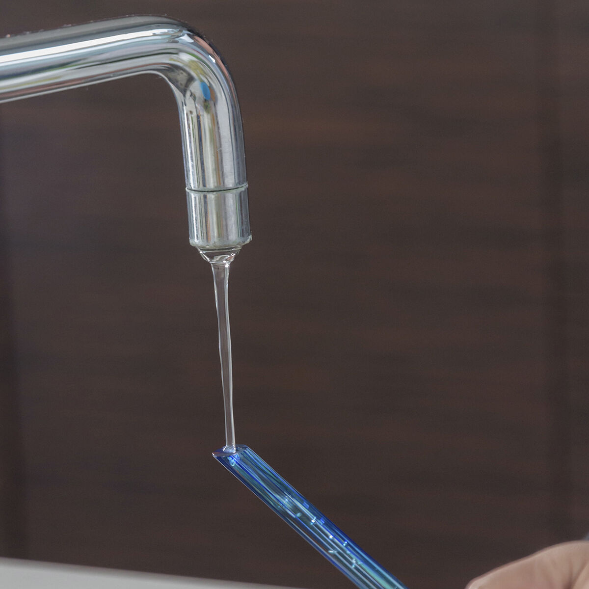 Wasser wird durch den Glasstiel einer Aqua-Loon-Kugel eingefüllt