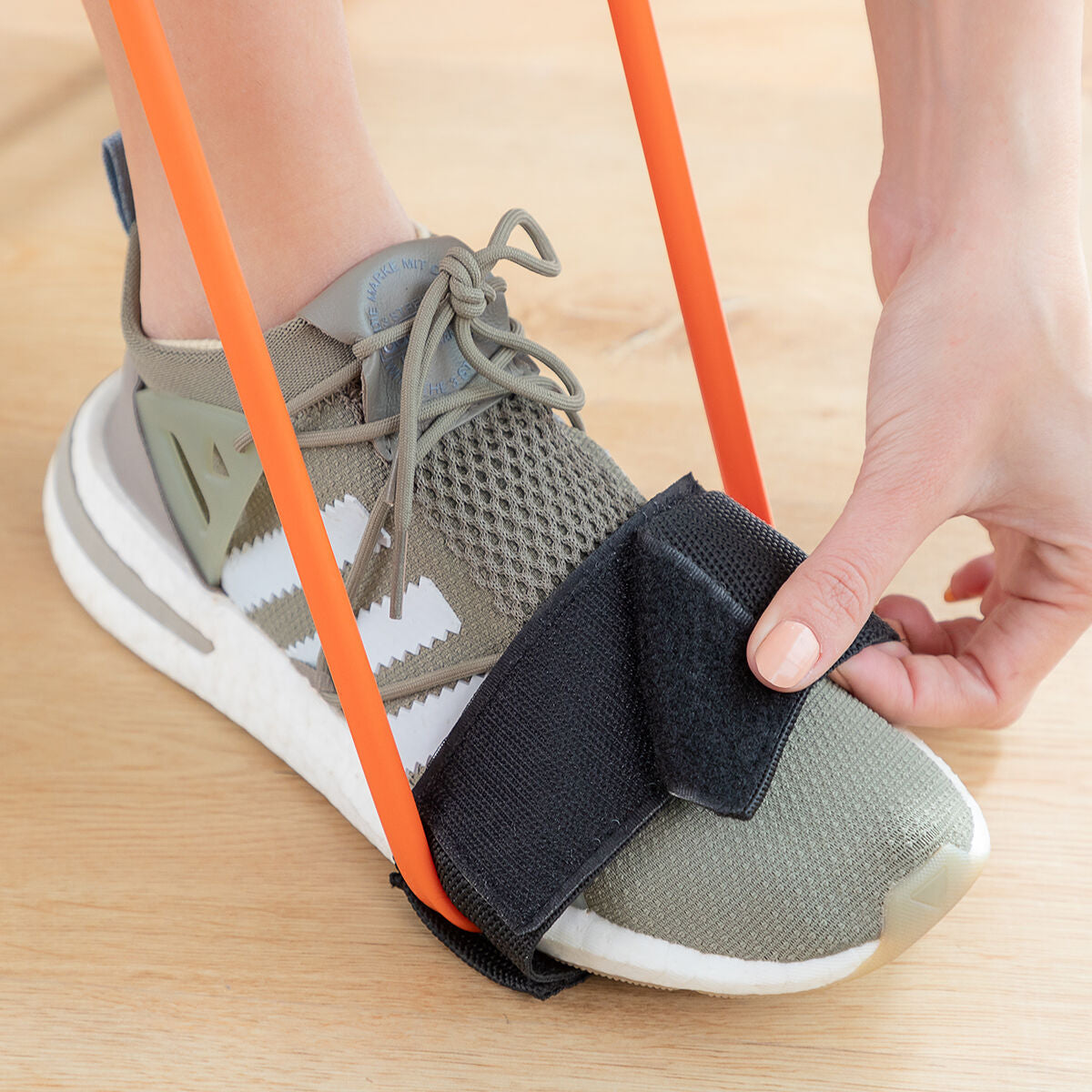 Schwarzer Bootrainer-Haltegurt wird über einem Schuh geschlossen