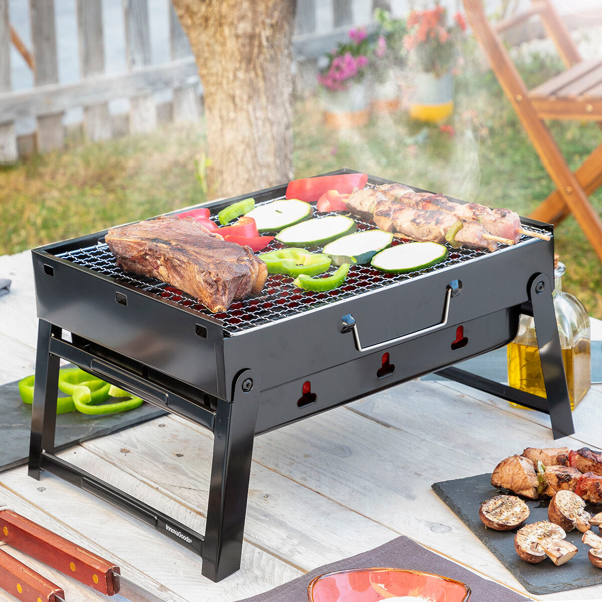 BearBQ-Holzkohlegrill mit ausgeklappten Beinen und Grillgut im Freien